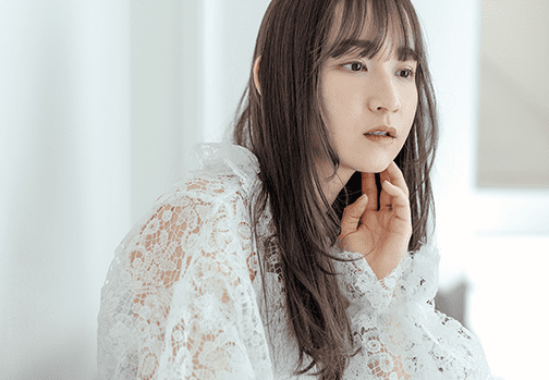 手の指先をあごにあてている女性の画像