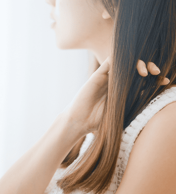 髪を指ですいてる女性の画像